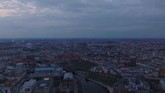 黄昏时分飞过柏林，展示城市的天际线和标志