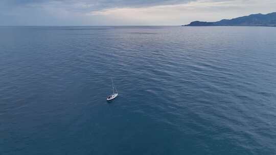 日落时分，帆船停泊在海湾中，水清澈碧绿