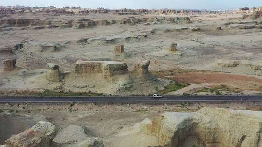 公路穿过新疆乌尔禾魔鬼城雅丹地貌群