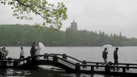 雨天的杭州西湖边散步的游客人群