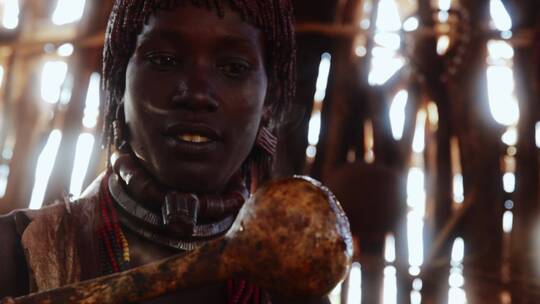 非洲女人拿着冒烟的勺子张望