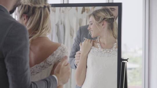 新郎新娘在礼服间照镜子