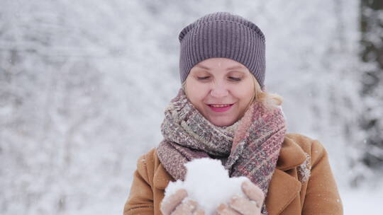 女人用双手把雪做成了雪球