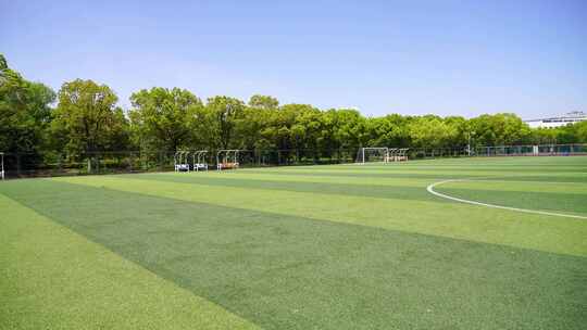 晴朗天气大学校园露天人造草坪足球场的景观