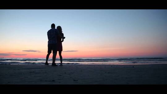 傍晚海滩沙滩上一对情侣拥抱求婚