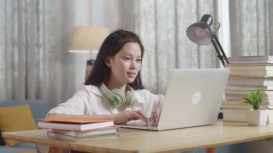 亚洲青少年学生在家用笔记本电脑庆祝，少女