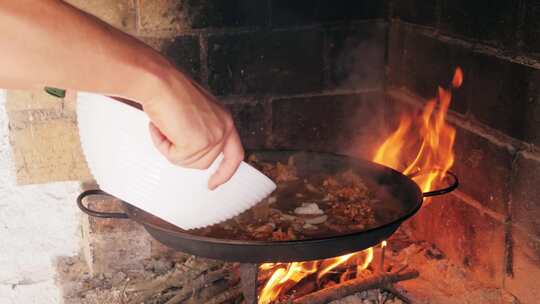 在炉子上烹饪传统西班牙海鲜饭厨师用贻贝虾