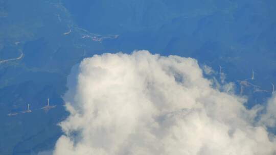 飞机窗外山脊上云风力发电风车