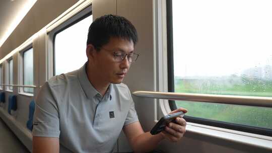 男子在卧铺火车过道上使用手机