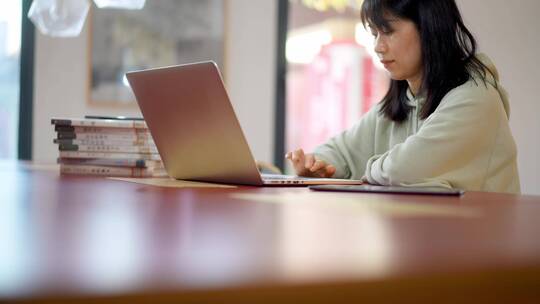 年轻女子在图书馆使用笔记本电脑上网
