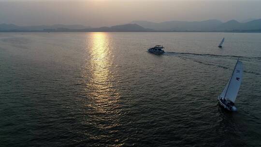 海上游艇帆船向远处航行的日落空镜头
