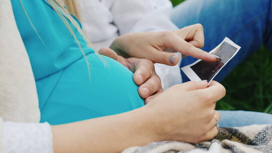 孕妇和男人坐在一起看超声波图像