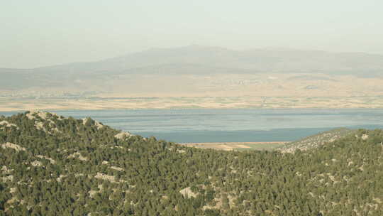 乘车在高山中旅行，可以看到山后广阔的湖泊
