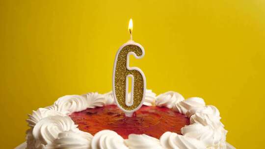 06.插在节日蛋糕里的数字6形式的蜡烛被