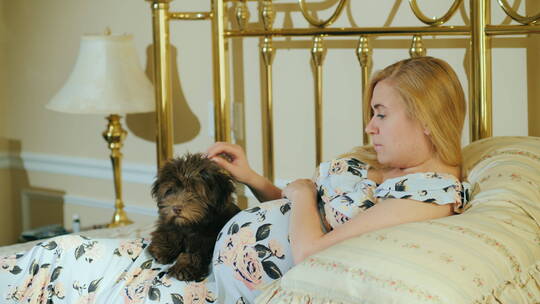 躺在沙发上的孕妇抚摸着小狗视频素材模板下载