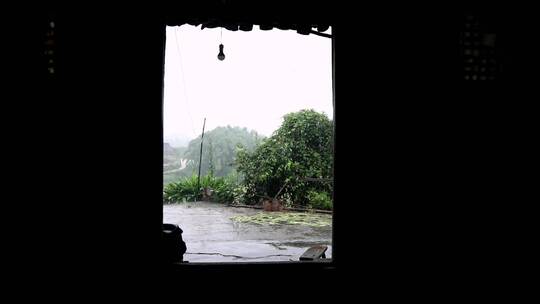 从门口看到的雨中乡村庭院景色