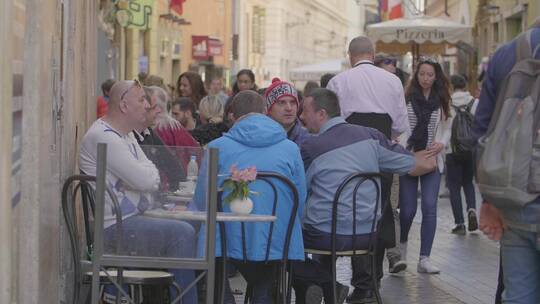 人们坐在罗马咖啡馆外