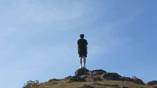 男子立于山顶眺望远方