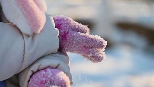 冬季阳光下儿童手捧雪花特写