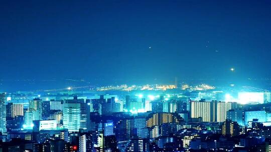 城市明亮的夜空下飞机起降，延时摄影