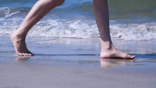 女孩赤脚走在海边的沙滩上视频素材