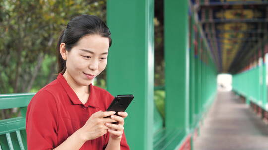 中国女性路边玩手机拍照通讯聊天