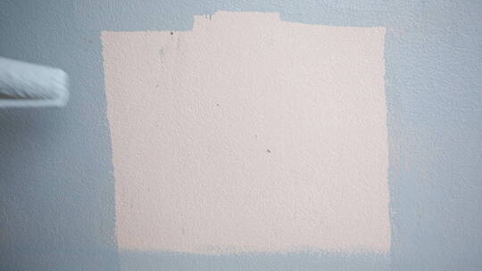 工人用蓝色油漆粉刷墙面
