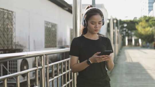 女人，智能手机，听音乐，人行道