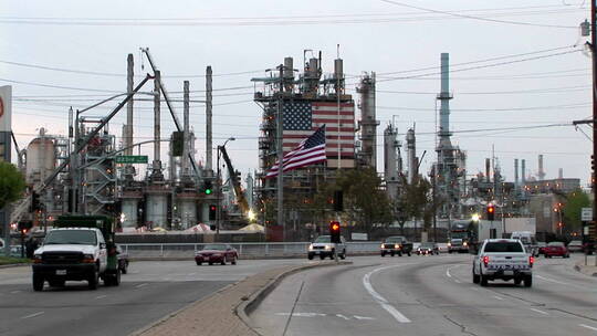 车辆经过一个装饰着两面美国国旗的工厂