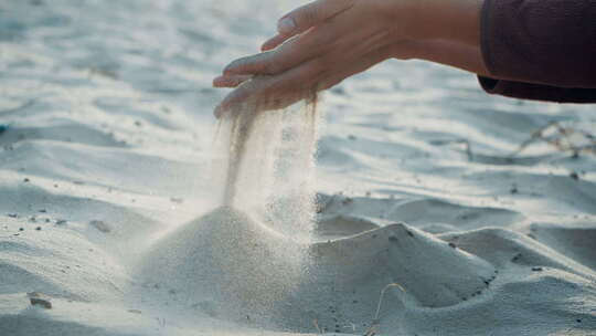 沙子穿过手指，沙子正在流淌