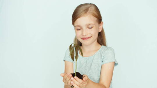 女孩手里拿着一棵小树植物视频素材模板下载