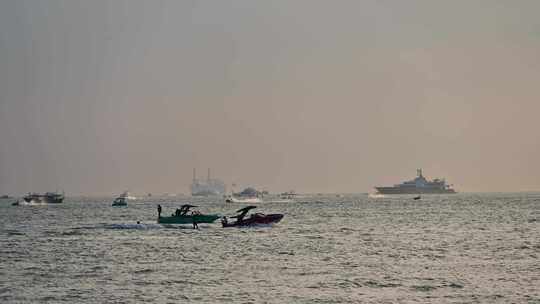 海南三亚湾海水浴场傍晚夕阳海上船只