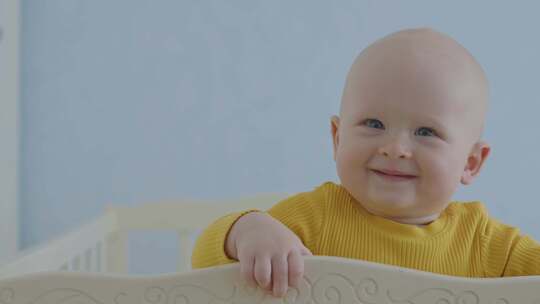 9个月大的男婴呆在婴儿床里微笑6