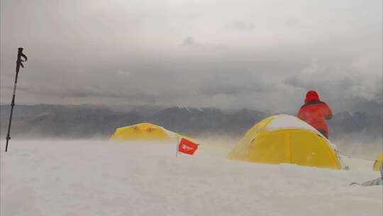 大风中的新疆慕士塔格峰雪山的登山者C1营地