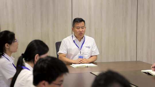 穿白色制服的男子在会议室发言