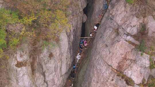 户外山林间多人徒步登山爬梯子穿越崎岖山路