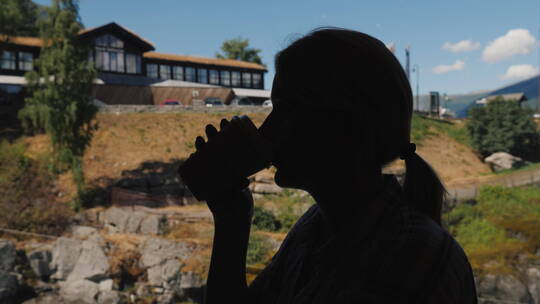 挪威山区一家咖啡馆里靠窗喝咖啡的女人的剪影