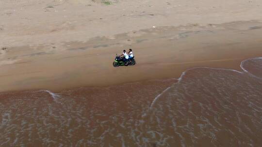 沿着海岸驾驶摩托车的人