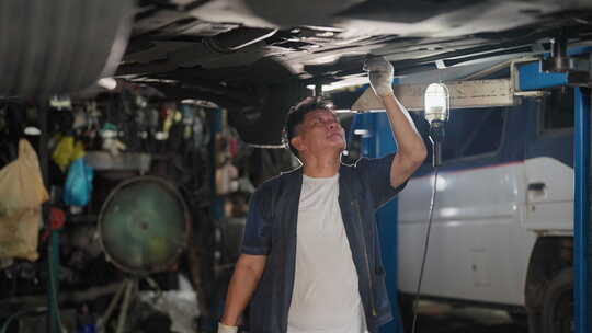 高级亚洲技术员或车库工人站在车下工作，并视频素材模板下载