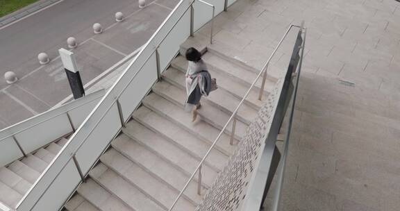 俯拍都市女青年 快步走在办公楼楼道阶梯上