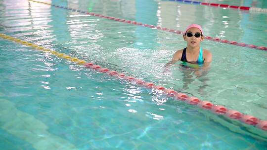 在泳池练习游泳的中国女孩