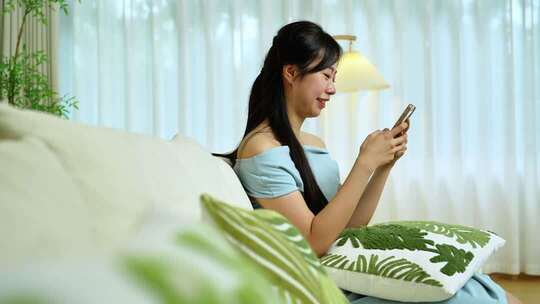 女性沙发上使用手机