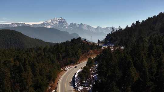 航拍雪山森林公路车辆行驶