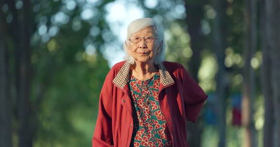 老年女性拄着拐杖在公园散步