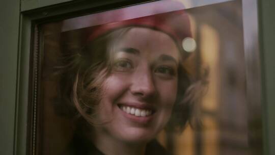 女模戴贝雷帽微笑看着窗外视频素材模板下载