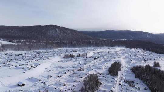 航拍新疆禾木雪景森林雪地小木屋禾木桥雪山