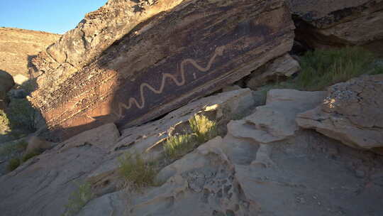 走向巨石，上面有美洲原住民的蛇岩画视频素材模板下载