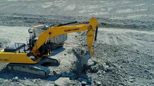 挖掘机将岩石装入卡车视频素材模板下载