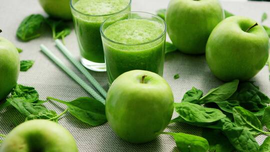 杯子中的绿色冰沙和苹果