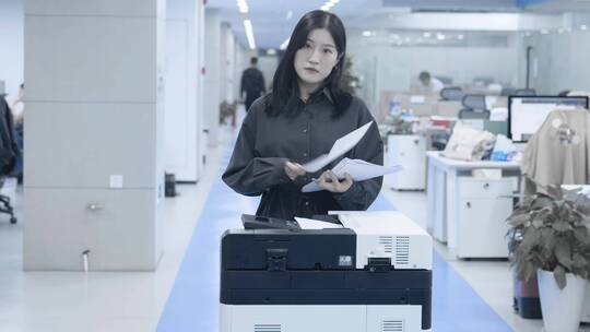 女生站在打印机前面机械的打印文件